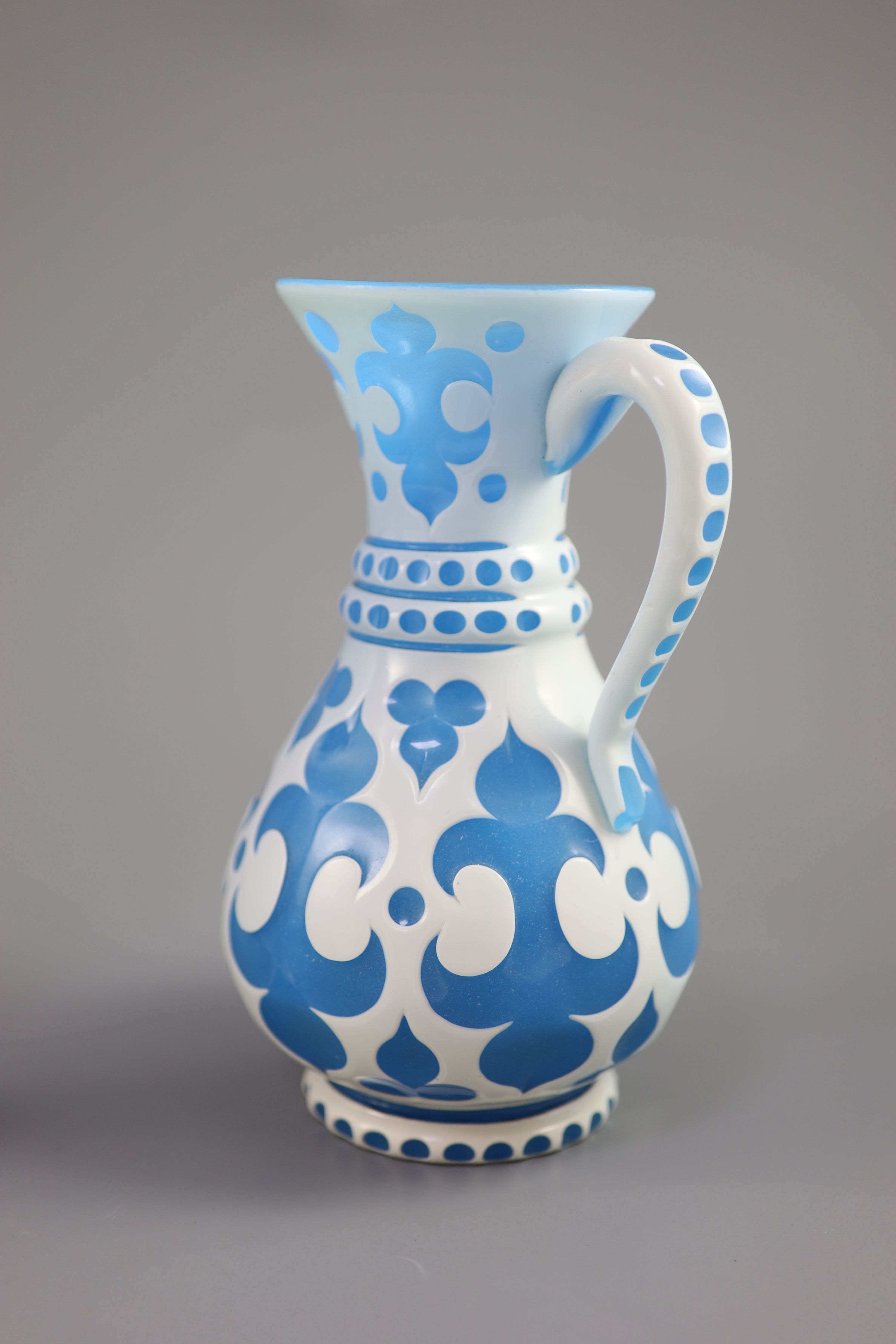 A Bohemian blue and white overlaid glass jug and a similar ruby and white overlaid glass vase, tallest 35cm